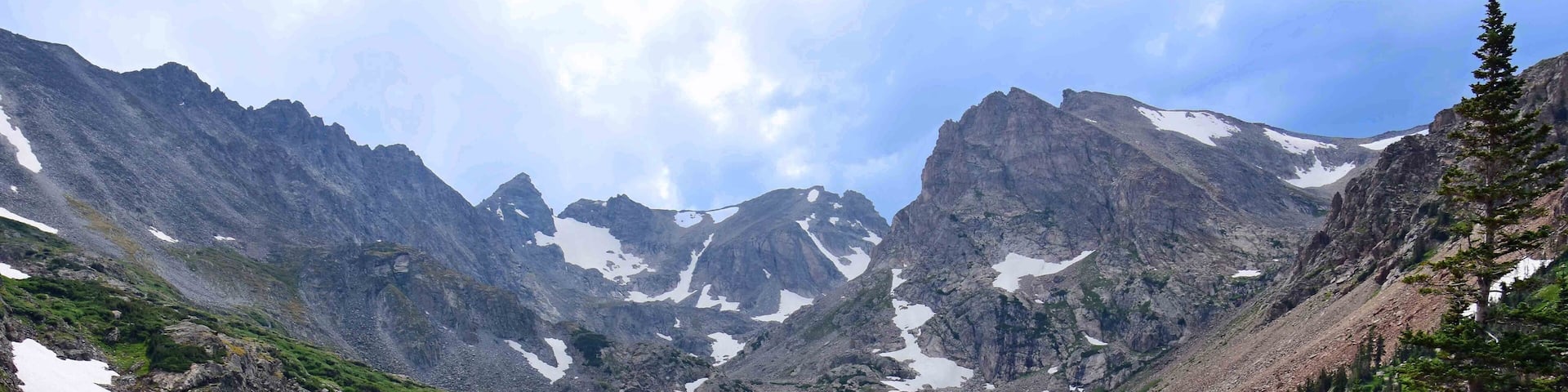 magnificent arapahoe, navajo, and shoshoni peaks with a mountain stream and snowfield on a sunny summer day along the lake isabele trail in the indian peaks wilderness area near nederland, colorado