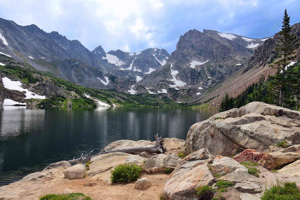 Un lago de montaña con costas rocosas y picos nevados.