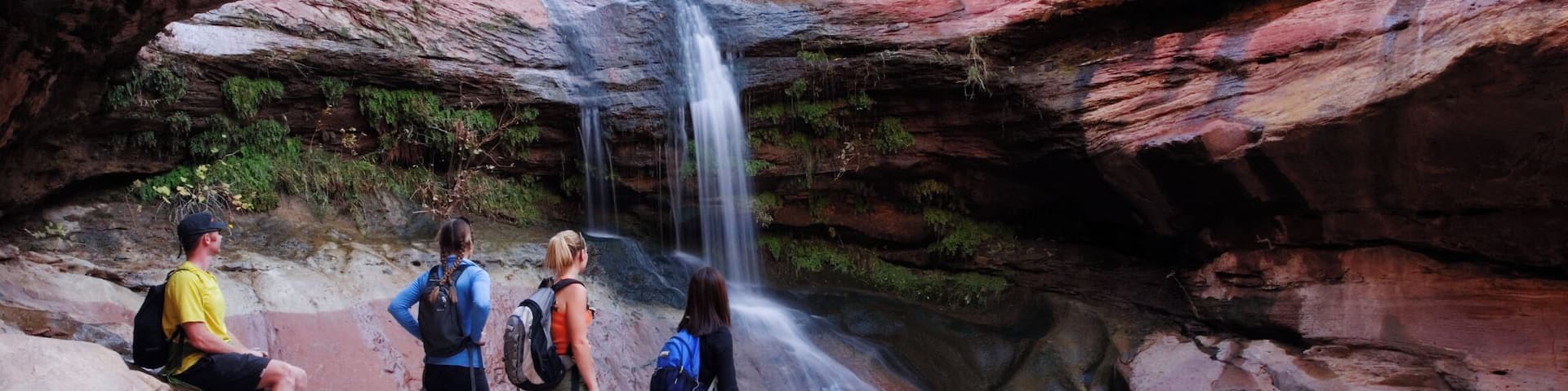 USA, Utah, group of hikers at canyon waterfall