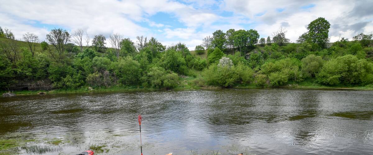 Packraft rubber boats and kayaks on sandy river bank, with dramatic sky. Selective focus. Active lifestyle concept.