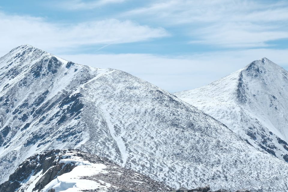Snow-covered mountain peaks under a clear sky.