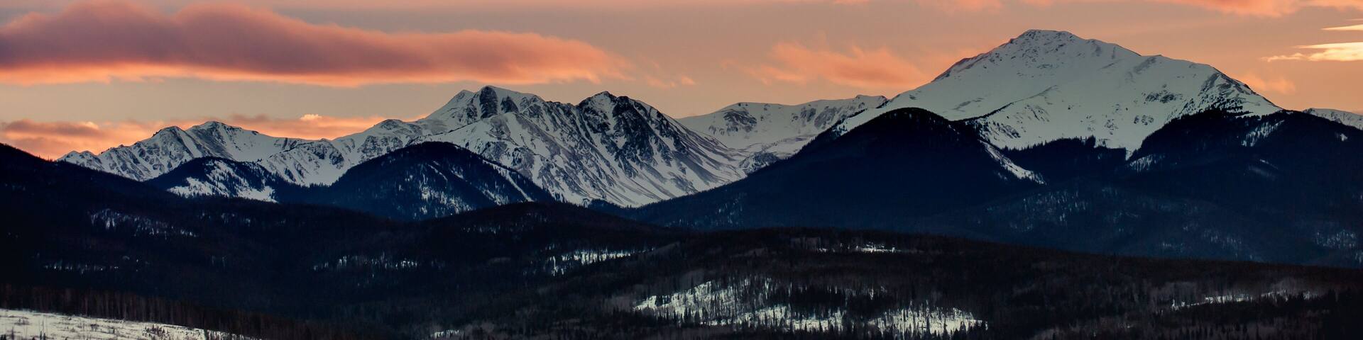 Sunset behind a snow covered mountain