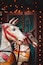 Un caballo de carrusel con arnés rojo y diseños decorativos.