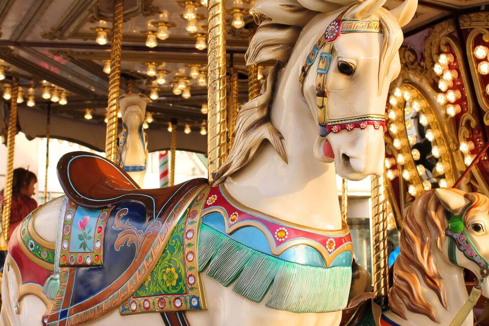 Um cavalo de carrossel com decorações elaboradas e um mostrador de relógio.