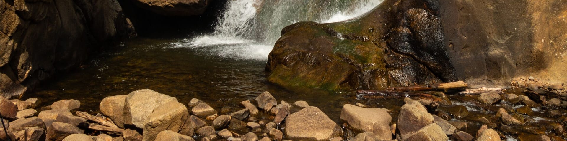 A waterfall cascading over rocky terrain surrounded by trees.