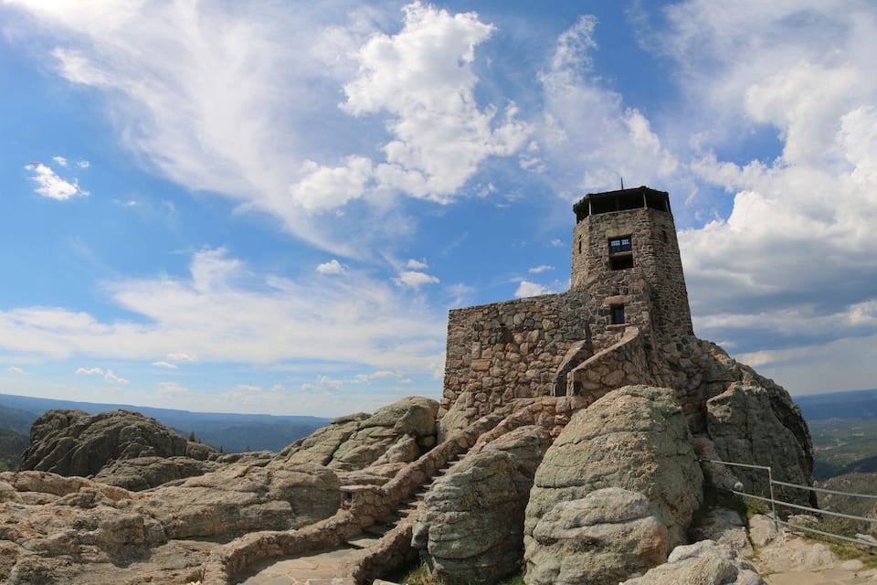 A stone tower on a rocky hill with a clear sky.