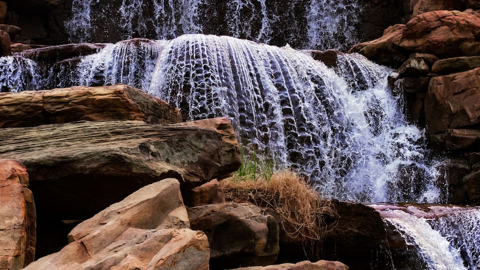 A waterfall cascading over rocks in a natural setting.