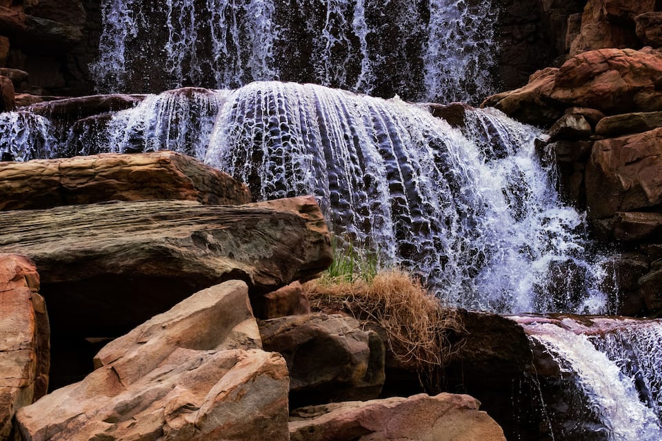Ein Wasserfall stürzt über Felsen in einer natürlichen Umgebung.