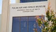 Het uiterlijk van het Tulsa Air and Space Museum, met grote ramen en borden.
