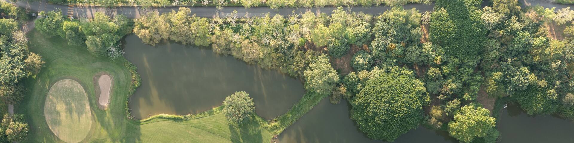 Landscape in golf course and water in lake or lakeside in aerial view. Include green field, lawn, grass. Design for golfers to play game, sport, outdoor recreation activity.