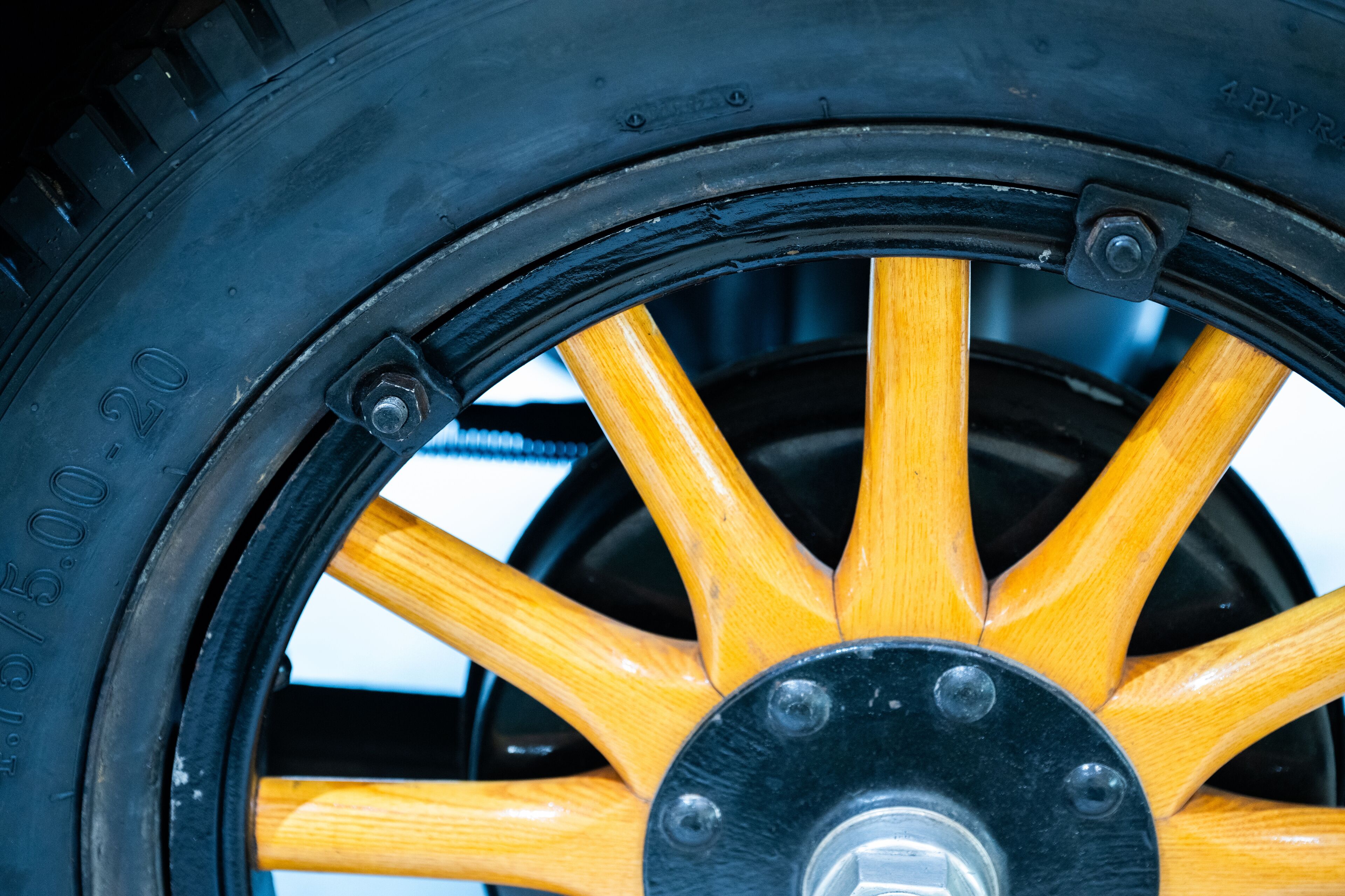 close-up of a vintage wooden-spoked automobile wheel.