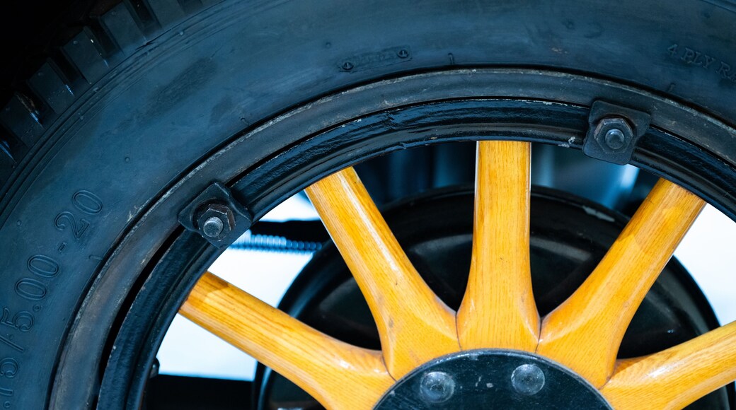 close-up of a vintage wooden-spoked automobile wheel.