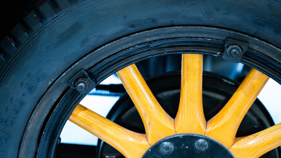close-up of a vintage wooden-spoked automobile wheel.