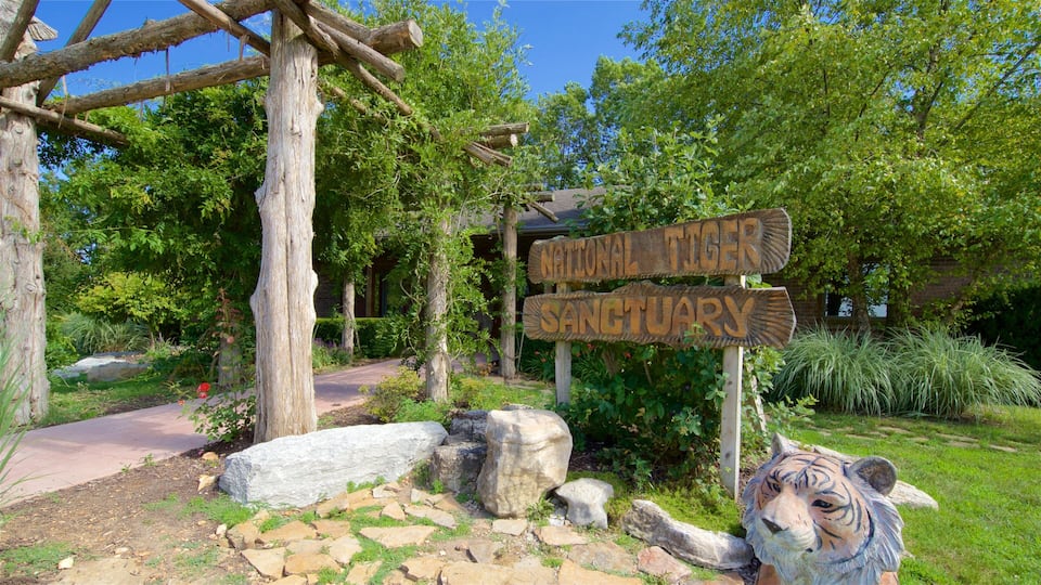 A wooden sign for the National Tiger Sanctuary surrounded by rocks and greenery.