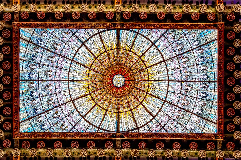 A stained glass window with intricate floral patterns and geometric designs.