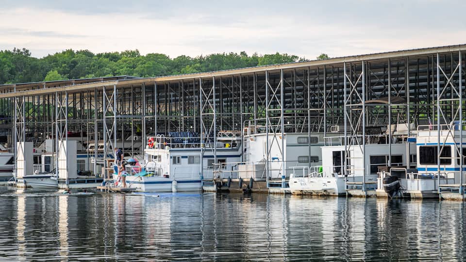 A marina with boats docked under a large covered structure.