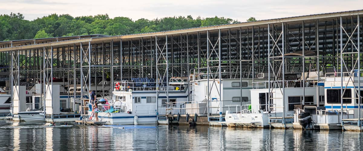 A marina with boats docked under a large covered structure.