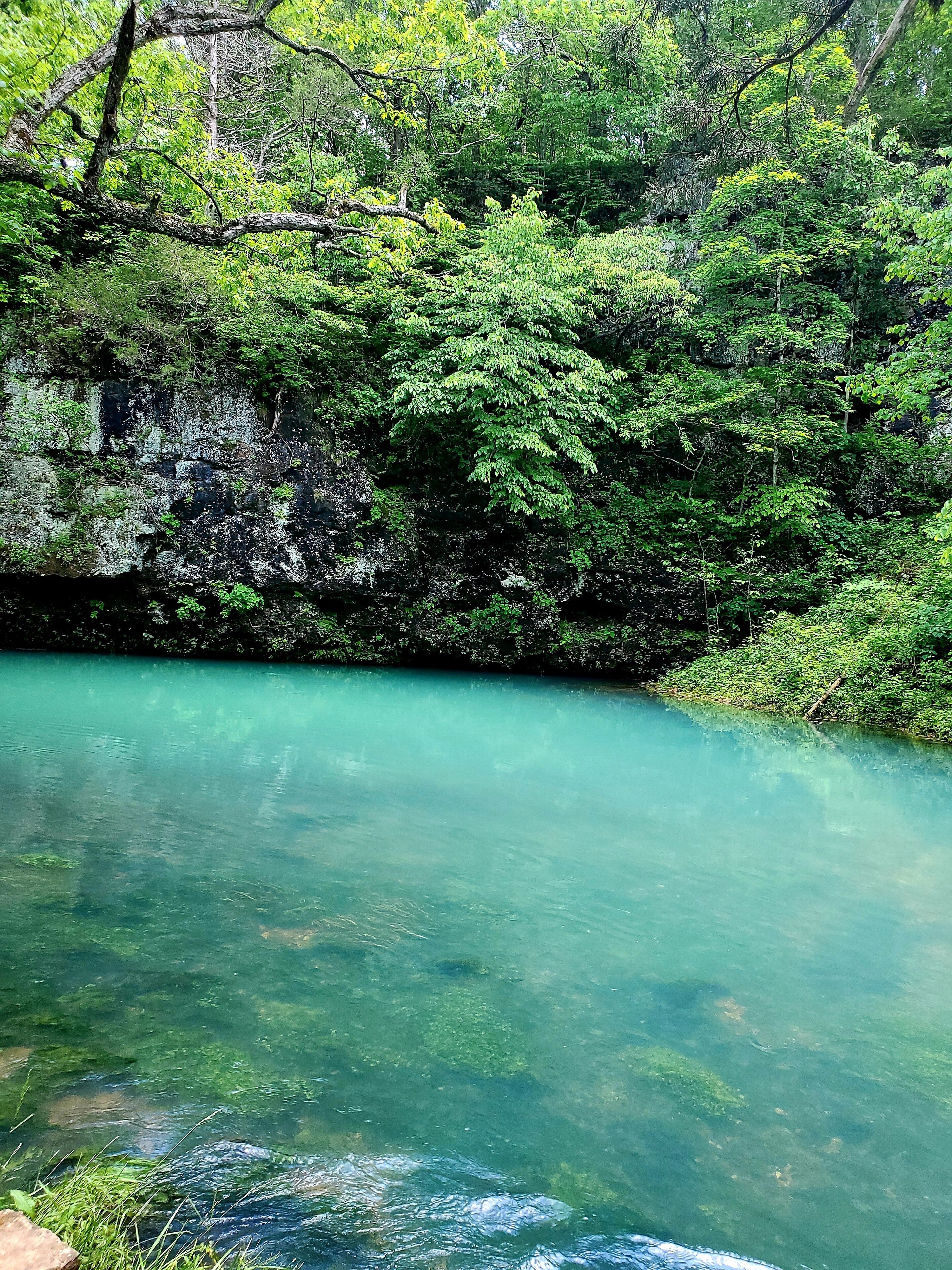 Underground spring near a cave showcasing beautiful refreshing blue water. Blue Springs on Current River in Missouri.