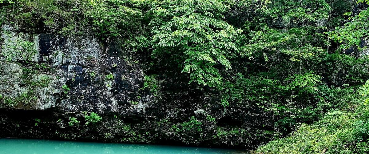 Underground spring near a cave showcasing beautiful refreshing blue water. Blue Springs on Current River in Missouri.