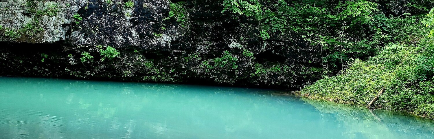 Underground spring near a cave showcasing beautiful refreshing blue water. Blue Springs on Current River in Missouri.