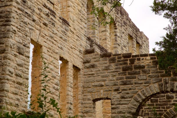 A stone building with arched windows and a brick archway.