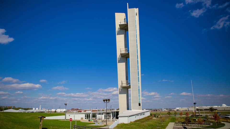 A tall, modern tower with balconies, set against a clear blue sky.
