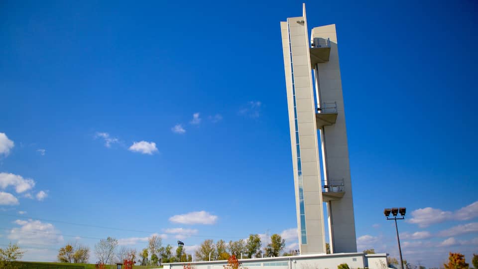 A tall, modern tower with a unique design, set against a clear blue sky with a few clouds.
