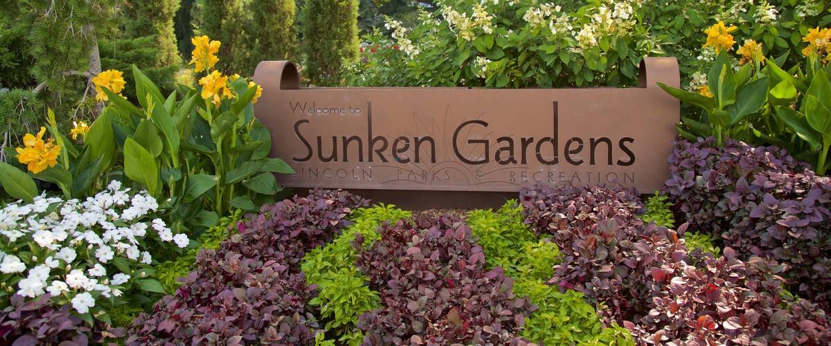 Sunken Gardens which includes a park, flowers and signage