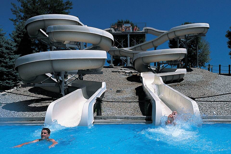 Um parque aquático com vários toboáguas e uma piscina.