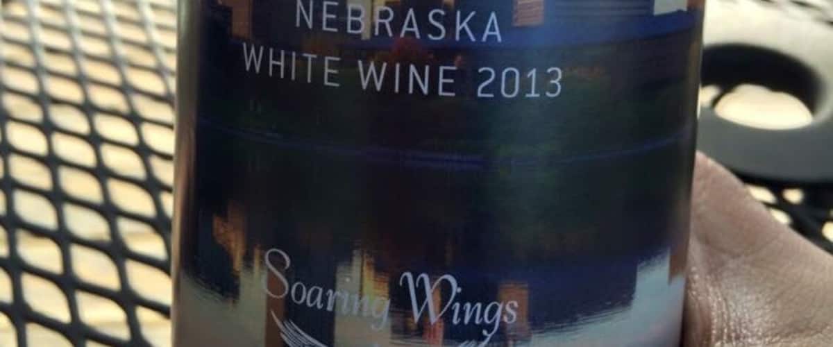 A bottle of Omaha We Don't Coast white wine with a cityscape label.
