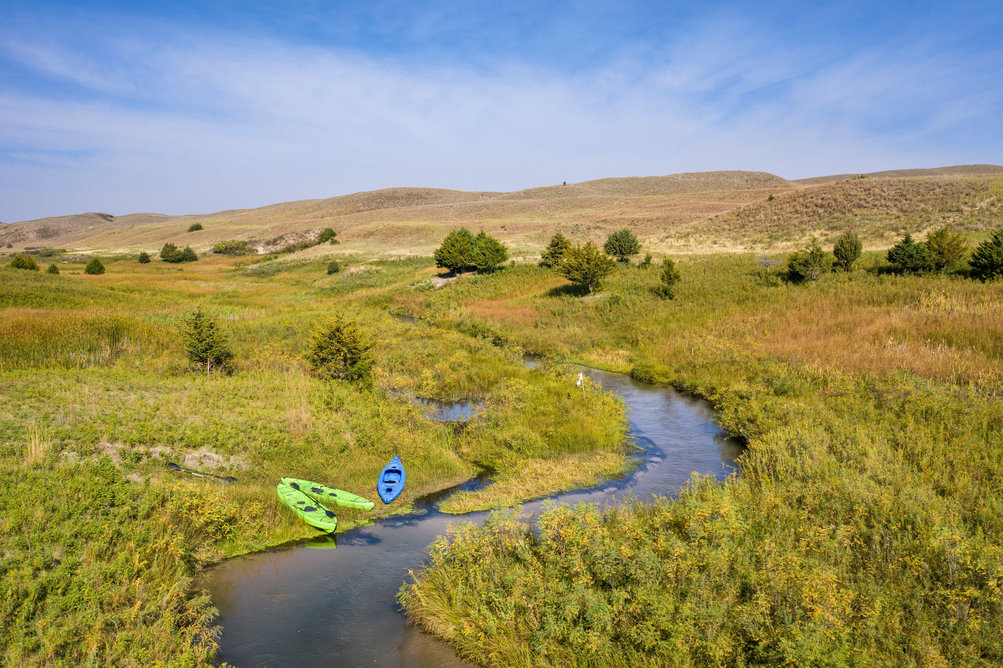 kayaks on the shore of a stream meandering in Nebraska Sandhills - North Fork of Dismal River near Dismal River Golf Club, early fall aerial view