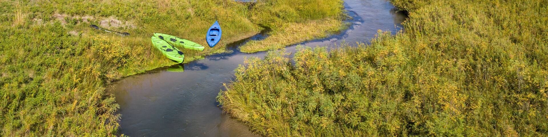 kayaks on the shore of a stream meandering in Nebraska Sandhills - North Fork of Dismal River near Dismal River Golf Club, early fall aerial view