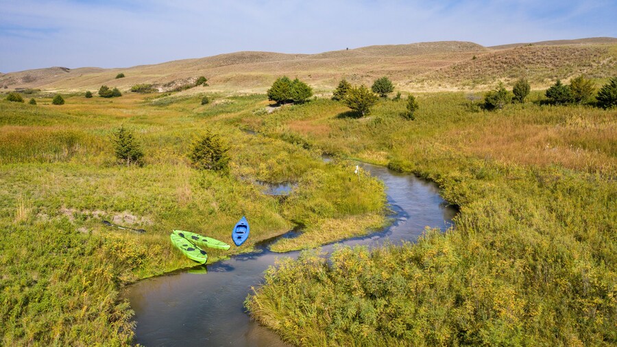 kayaks on the shore of a stream meandering in Nebraska Sandhills - North Fork of Dismal River near Dismal River Golf Club, early fall aerial view
