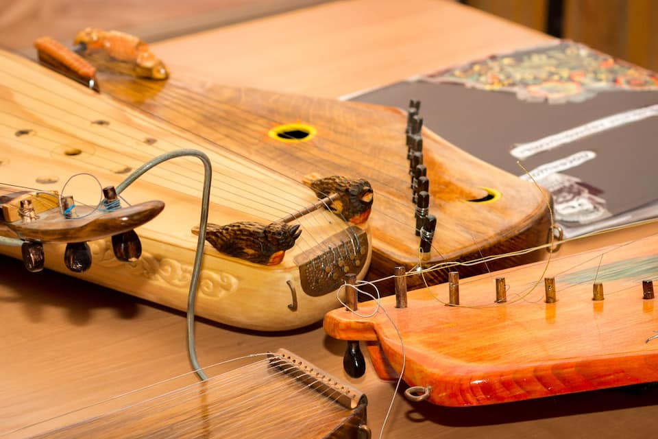 A traditional stringed instrument with a wooden body, metal tuning pegs, and a bridge.