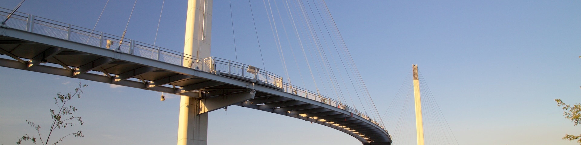 Puente peatonal Bob Kerrey mostrando un atardecer, un puente y un río o arroyo
