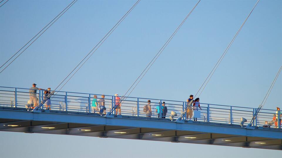 A pedestrian bridge with people walking across it.