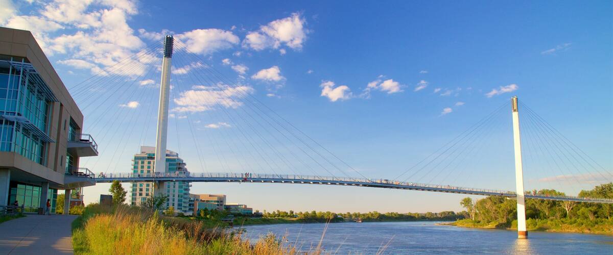 Bob Kerrey Pedestrian Bridge que inclui um rio ou córrego, um pôr do sol e uma ponte