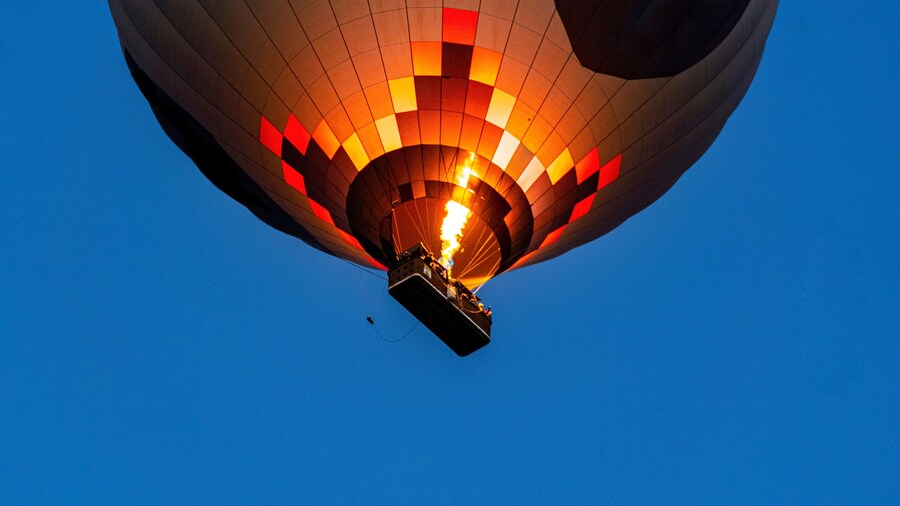 Hot air balloon flying over rock landscape at Cappadocia Turkey.