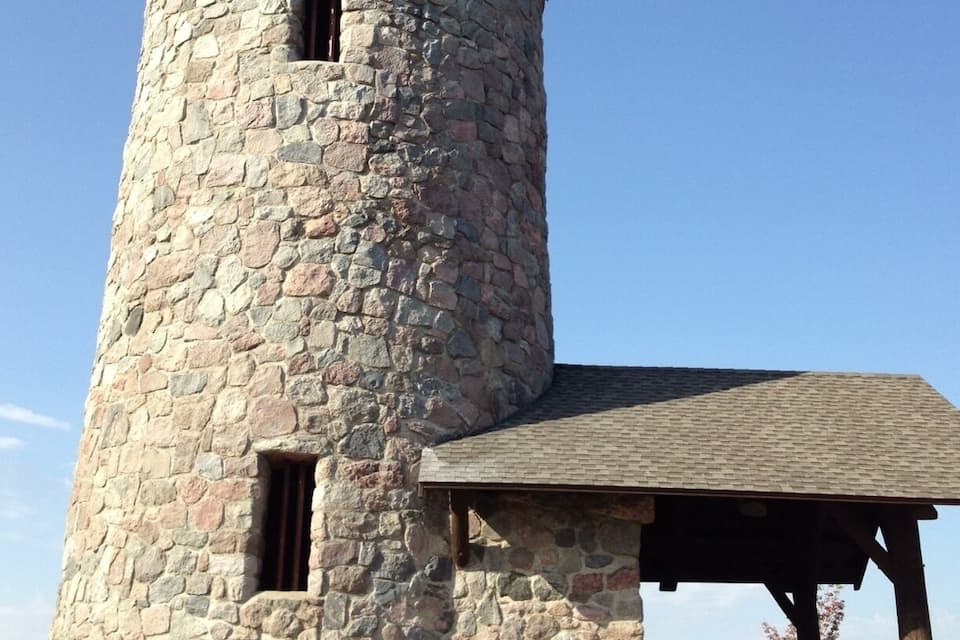 A stone tower with a wooden shelter.