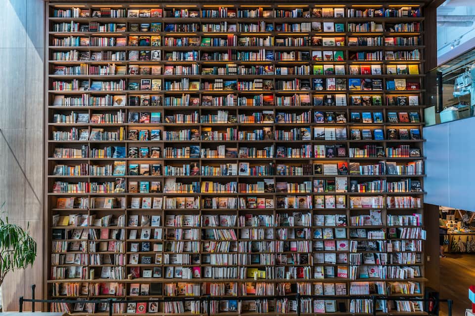 A large, well-lit bookcase filled with books and magazines.