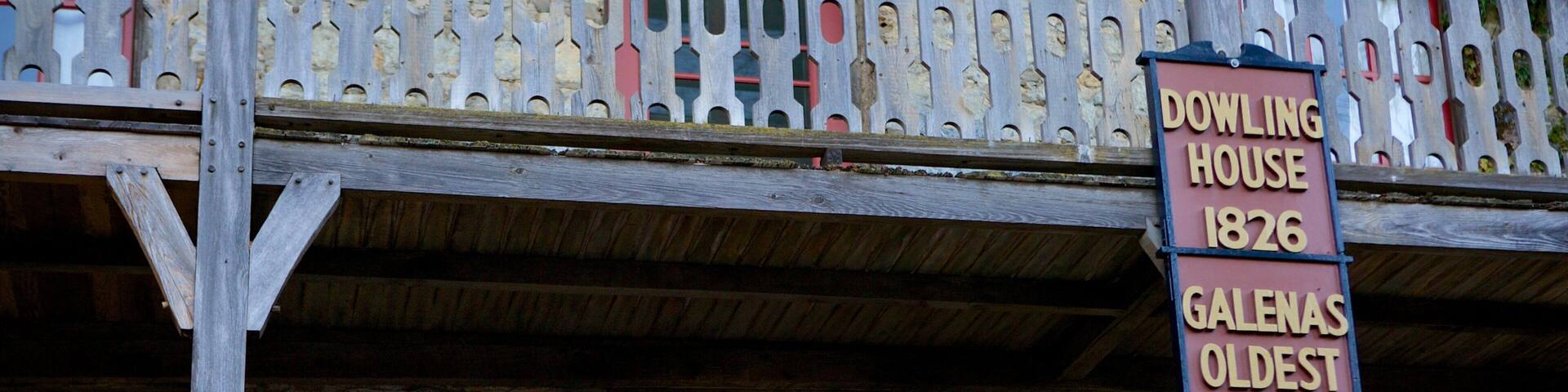 Un balcón de madera con un cartel que indica que el edificio es Dowling House, construido en 1826, y afirma ser la casa más antigua de Galena.