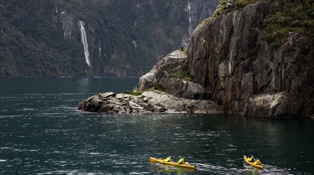 Kayakers enjoy the scenery and waterfalls of Milford Sound, one of New Zealand's most popular tourist destinations