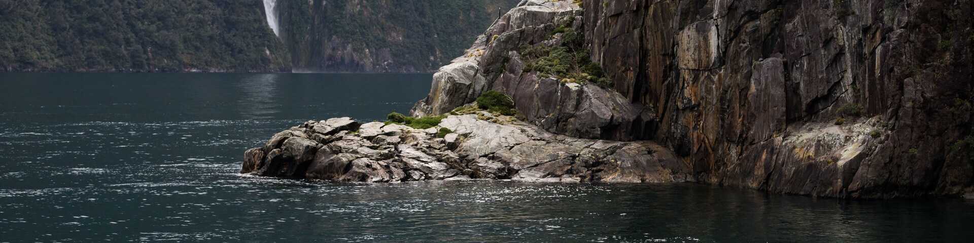 Kayakers enjoy the scenery and waterfalls of Milford Sound, one of New Zealand's most popular tourist destinations