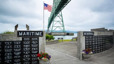A memorial with names and dates, a bridge, and an American flag.