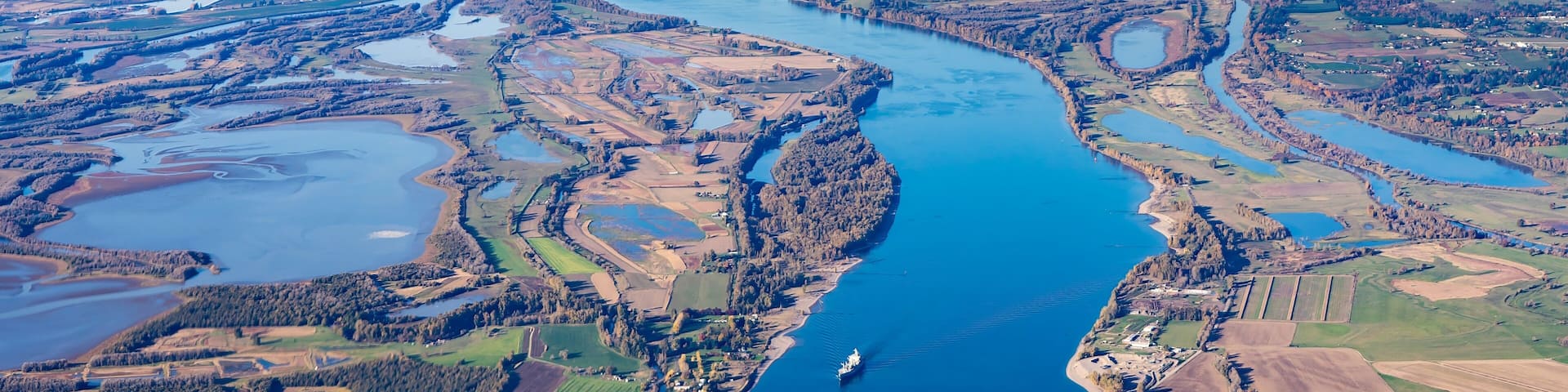 Aerial view of Sauvie island farm and wildlife area and the Columbia River leading west toward Astoria, Oregon, from Vancouver, Washington