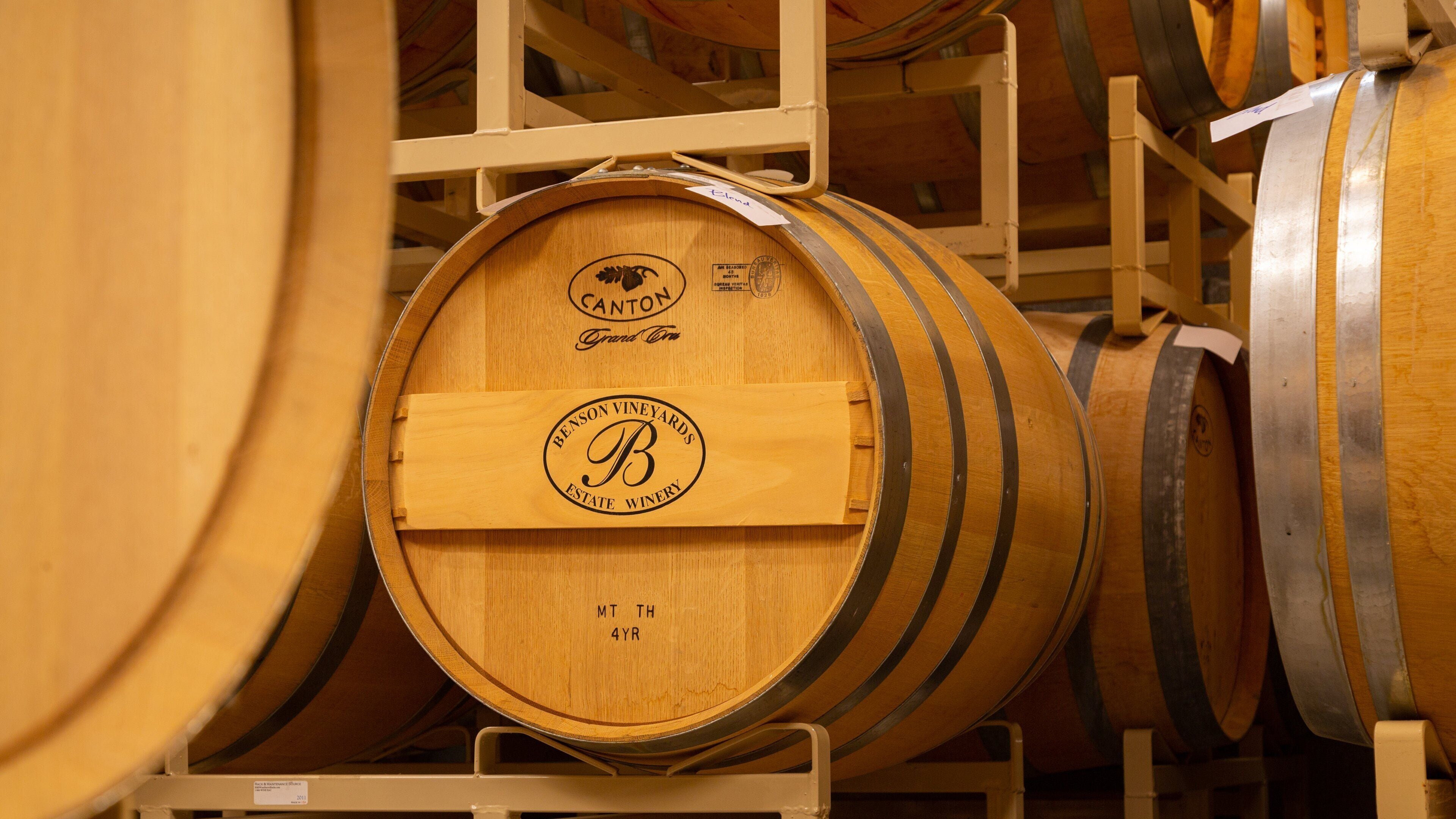 Wooden wine barrels stacked in a warehouse.