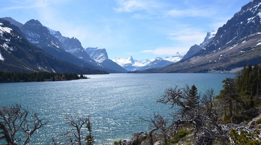 Just after the entrance to Glacier National Park there is a small path leading out on a rock formation that provides incredible views of the mountain scape across the lake. We thought we would be able to take the Going To The Sun Road through the park, but itâs opening was delayed (it was already the middle of May) due to a late thaw and portions of the road were still covered in snow. This little overlook, only a short walk past the gate, was perfect after having driven over an hour out of the way to drive through the park. #mountains #nationalparks #roadtrip