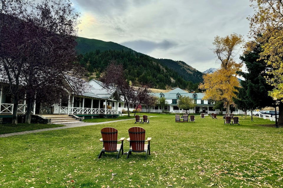 A grassy area with outdoor seating and a building with a porch.