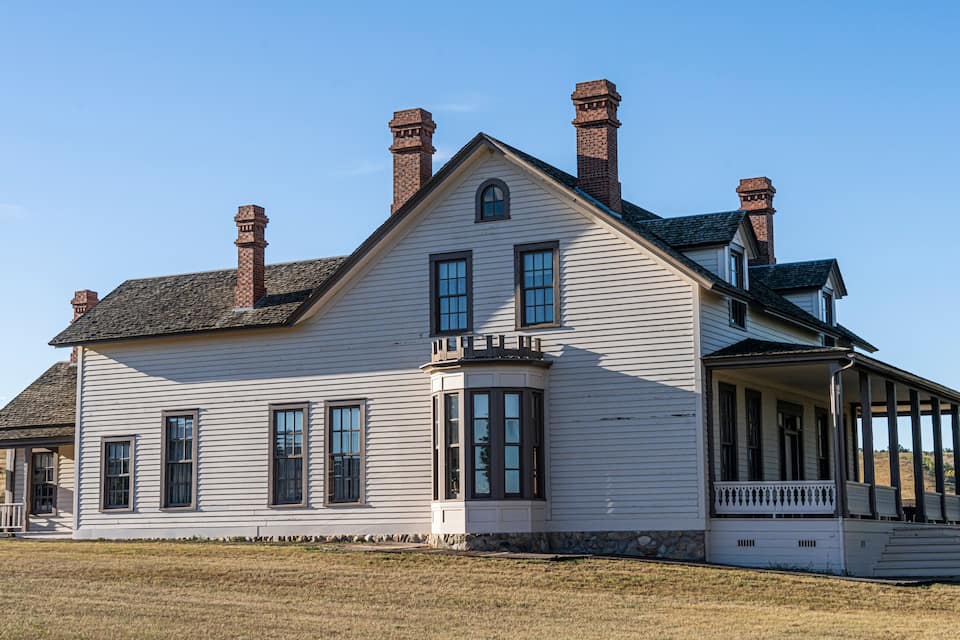 A large white house with multiple chimneys and a porch.