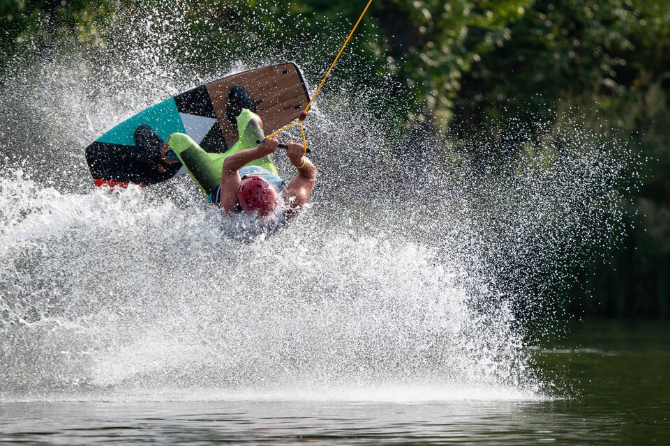 A person water skiing with a wakeboard, surrounded by splashing water.